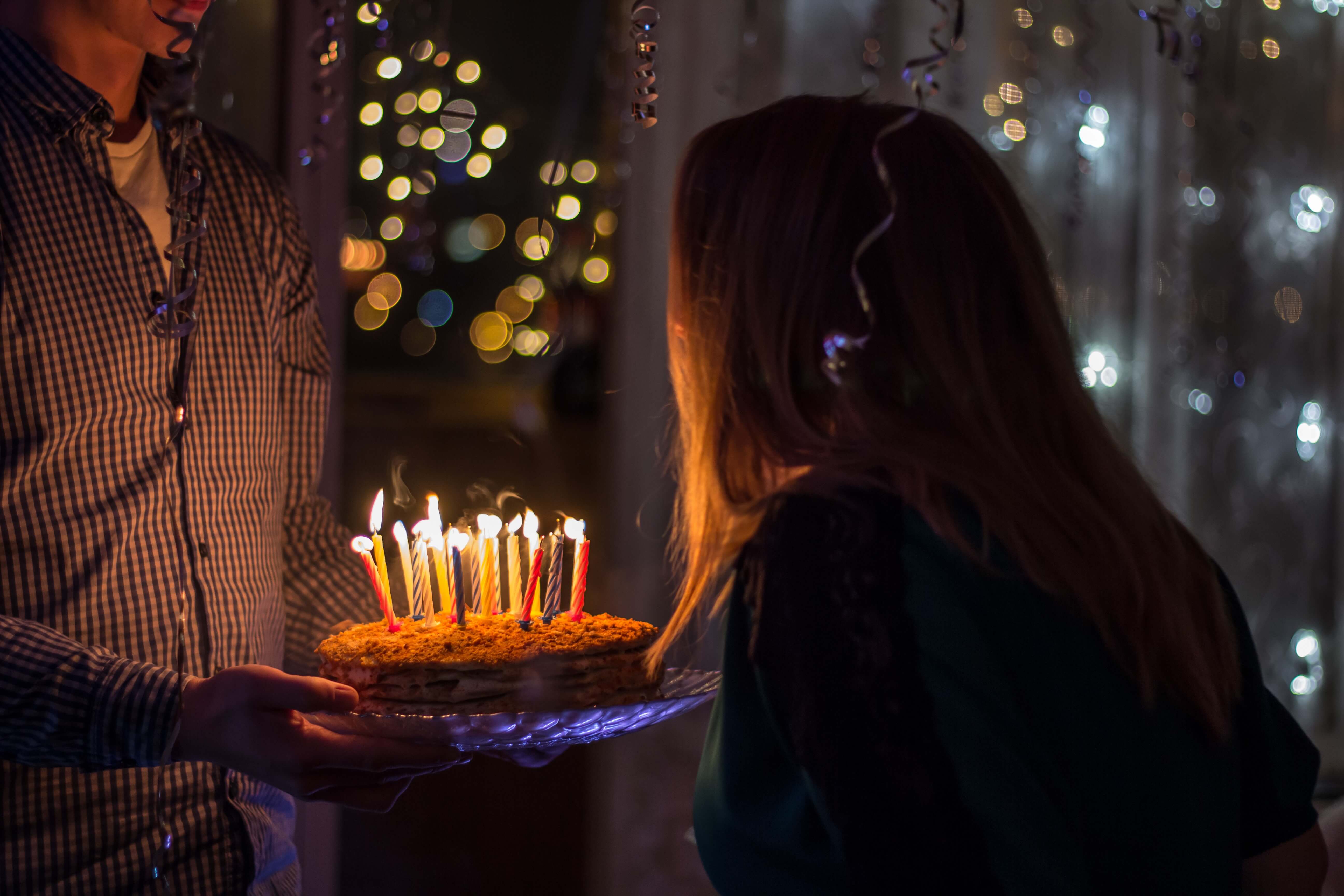 A girl blowing candles at a birthday party